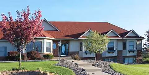 Front view of a single-story assisted living facility with landscaping and a walkway.
