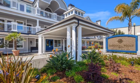 Exterior view of Cardinal Point senior living with a covered entrance and landscaped garden.