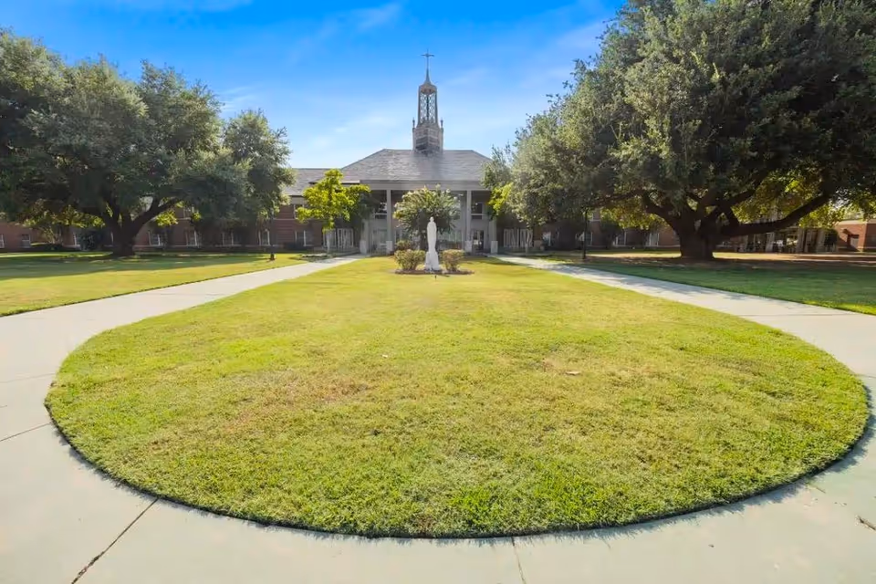 Front view of Christus St Joseph Home with a circular grassy courtyard and surrounding walkways.