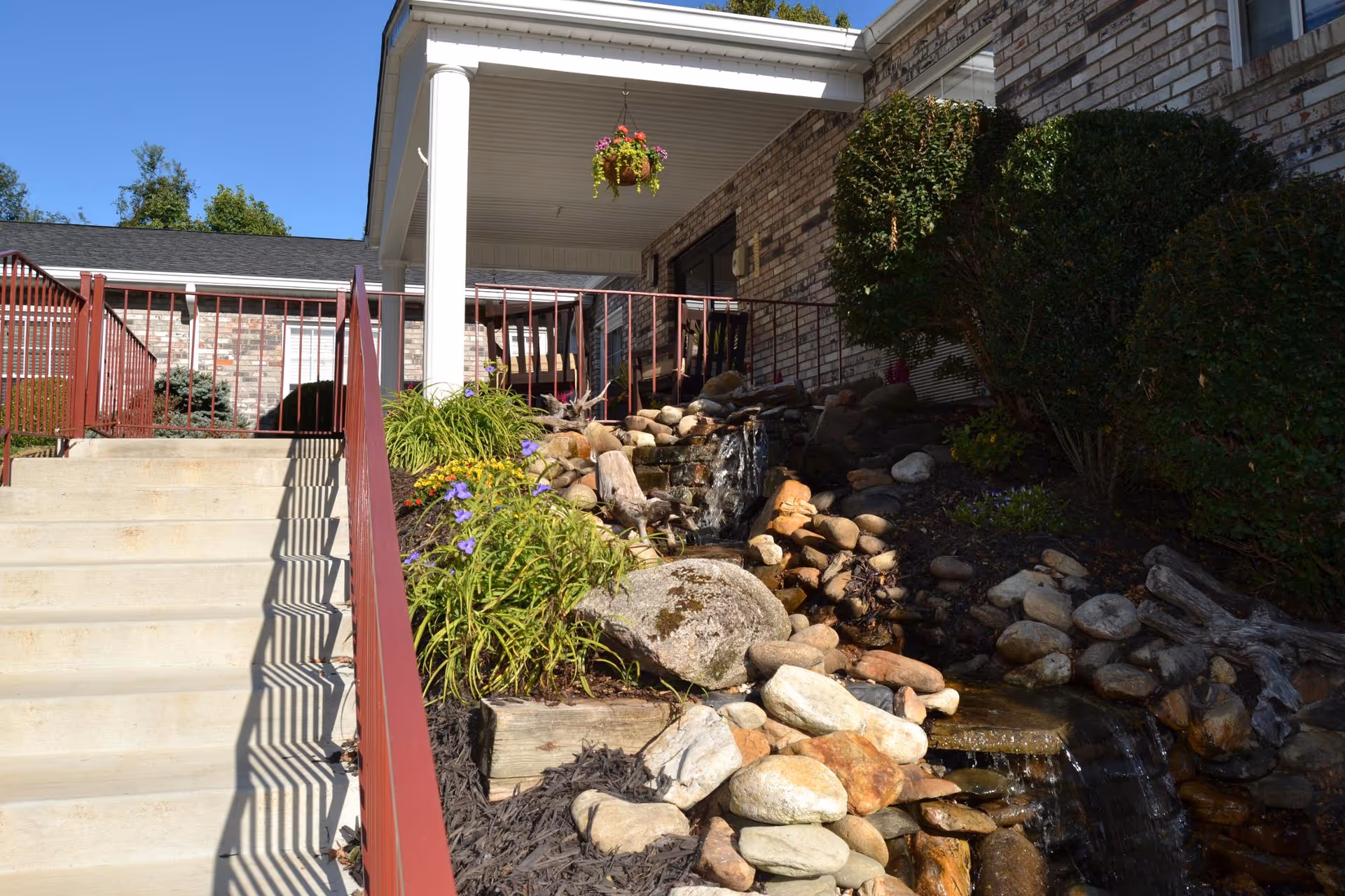 Exterior view of the Hermitage Health and Rehabilitation Center featuring a stone pathway and landscaping.