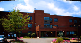 Exterior view of Hunt Nursing and Rehab Center, showing the entrance and landscaped front area.