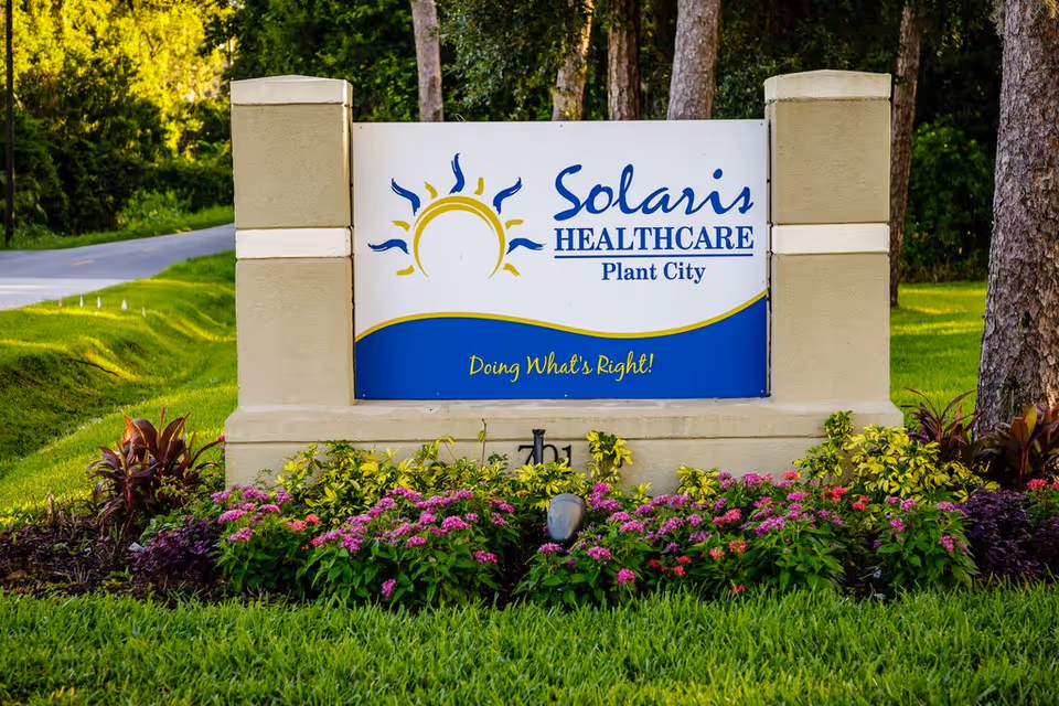 Entrance sign reading "Solaris Healthcare Plant City" surrounded by landscaped flowers and trees.