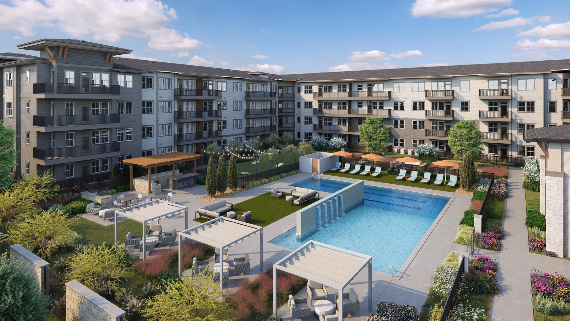 Outdoor courtyard area of Amberlin Pflugerville featuring a large swimming pool with water features, lounge chairs with orange umbrellas, multiple pergolas with seating, landscaped gardens, and a multi-story residential building surrounding the courtyard under a partly cloudy sky.