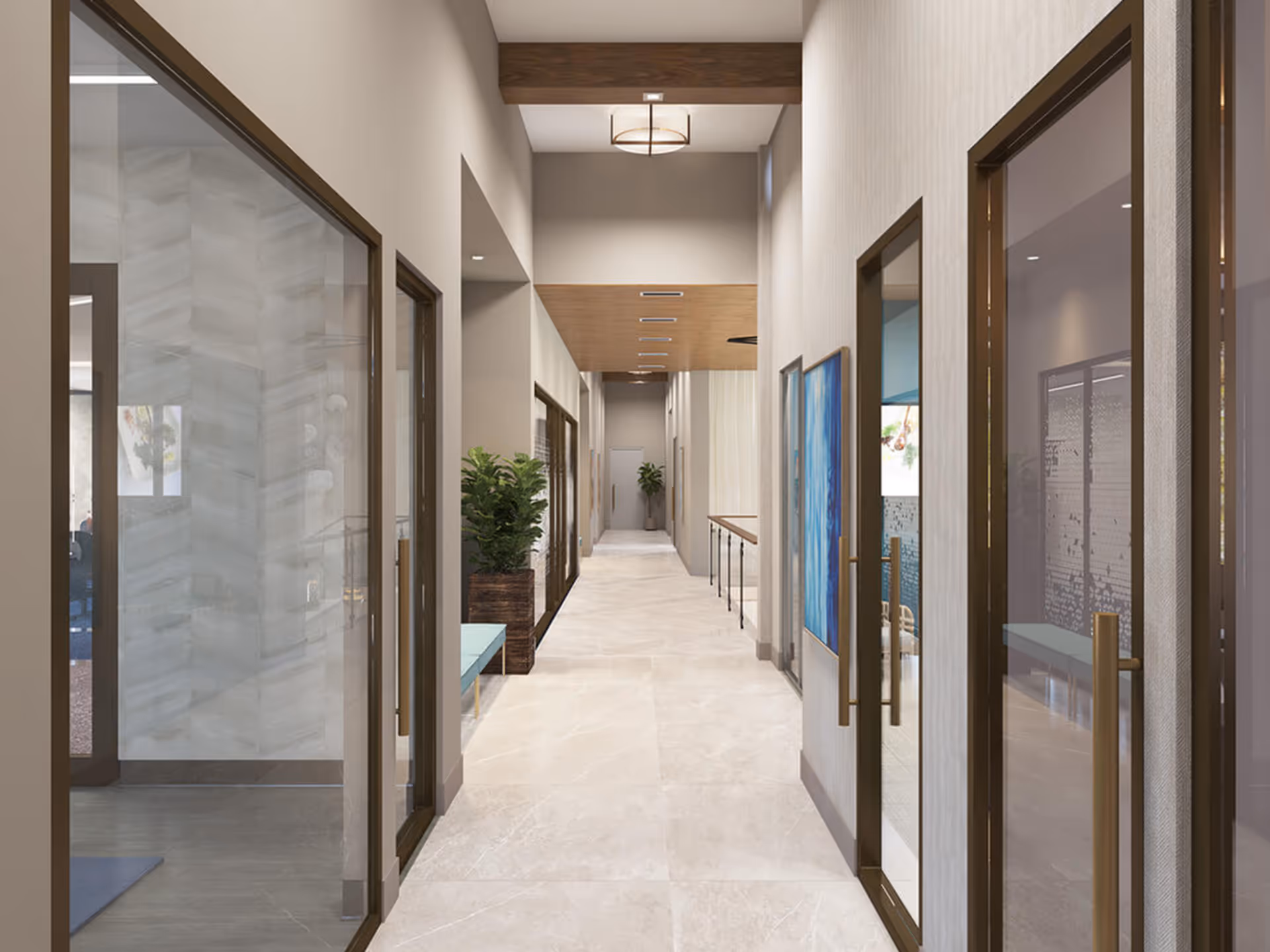 Bright modern interior corridor with glass-door rooms, benches, plants and artwork.