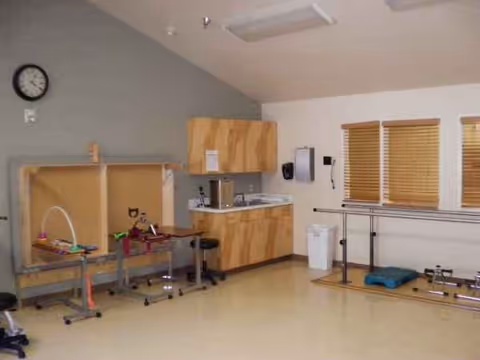 Interior rehab room at Sabine Retirement and Rehab Center with therapy equipment and windows.