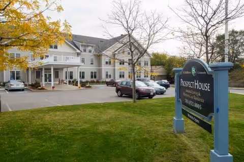 Exterior view of Prospect House Assisted Living and Memory Care with a parking lot.
