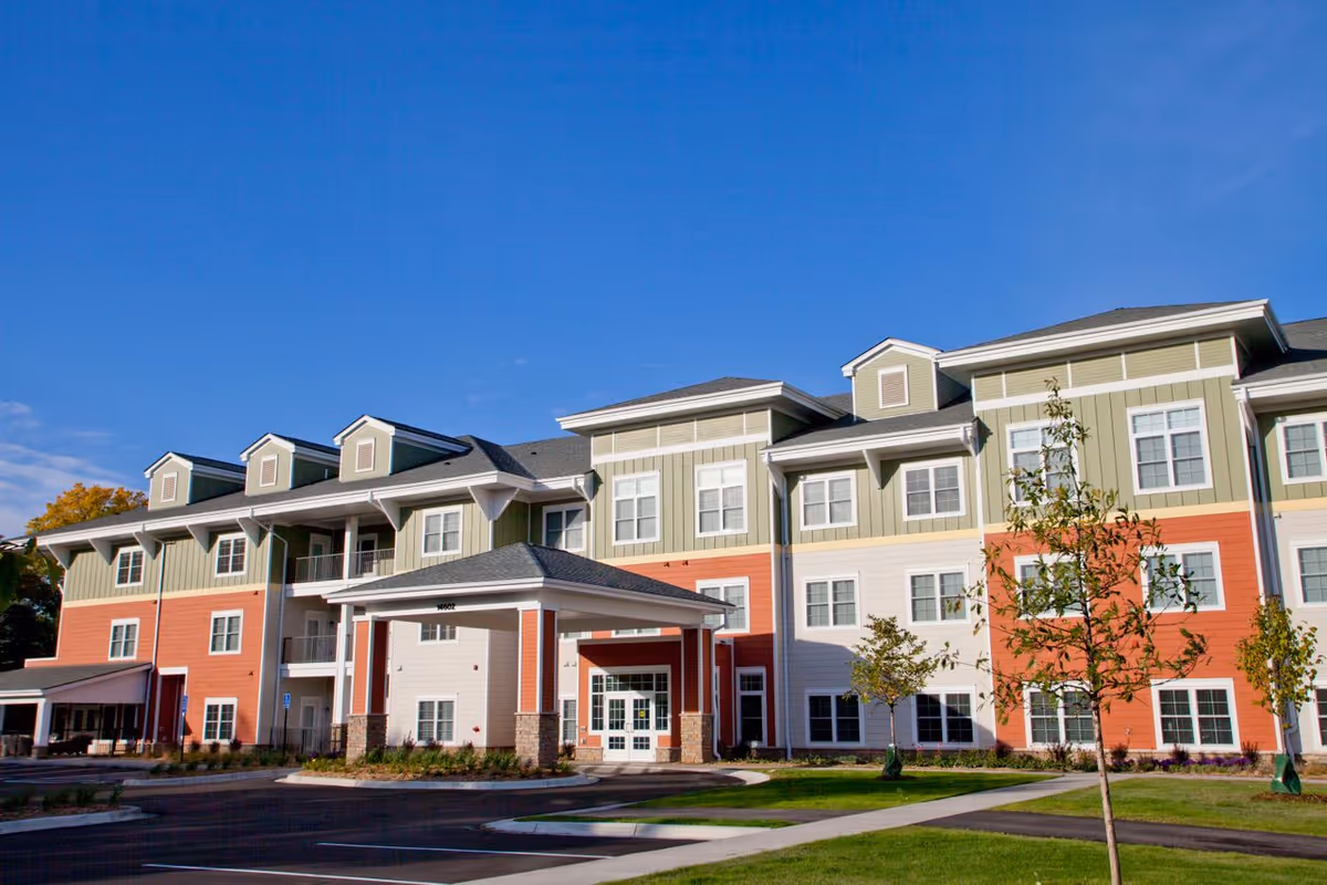 Exterior view of Keystone Place at LaValle Fields, a multi-story senior living facility with a colorful facade and manicured landscaping.