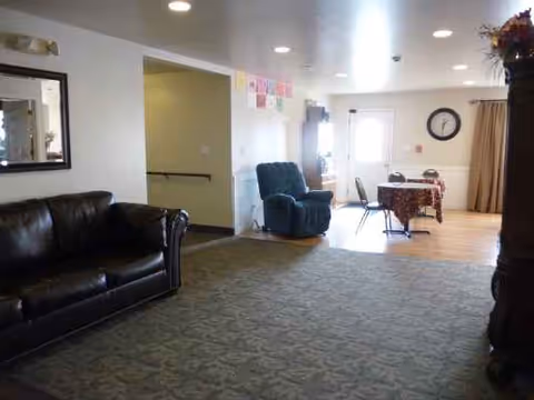 A comfortable living area in Crystal Grove with couches, recliner, and a dining table.