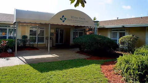 Facade of Winter Haven Health and Rehabilitation Center with an entrance under a curved canopy.