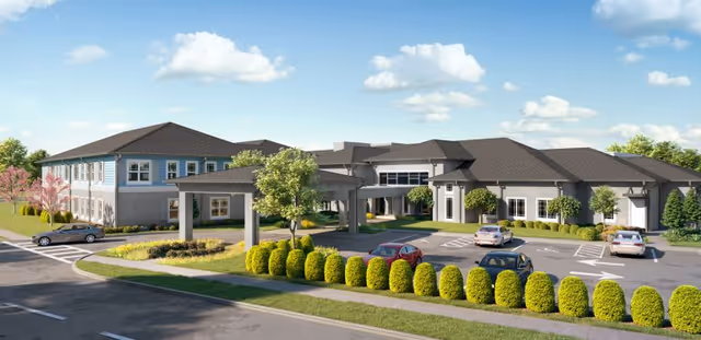 Front entrance of a senior living facility with a covered porte-cochere, landscaped drive and parked cars.