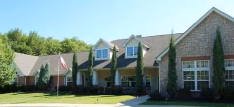 Brookdale Salem facility exterior with brick and stone facade, manicured lawn, and flagpole.