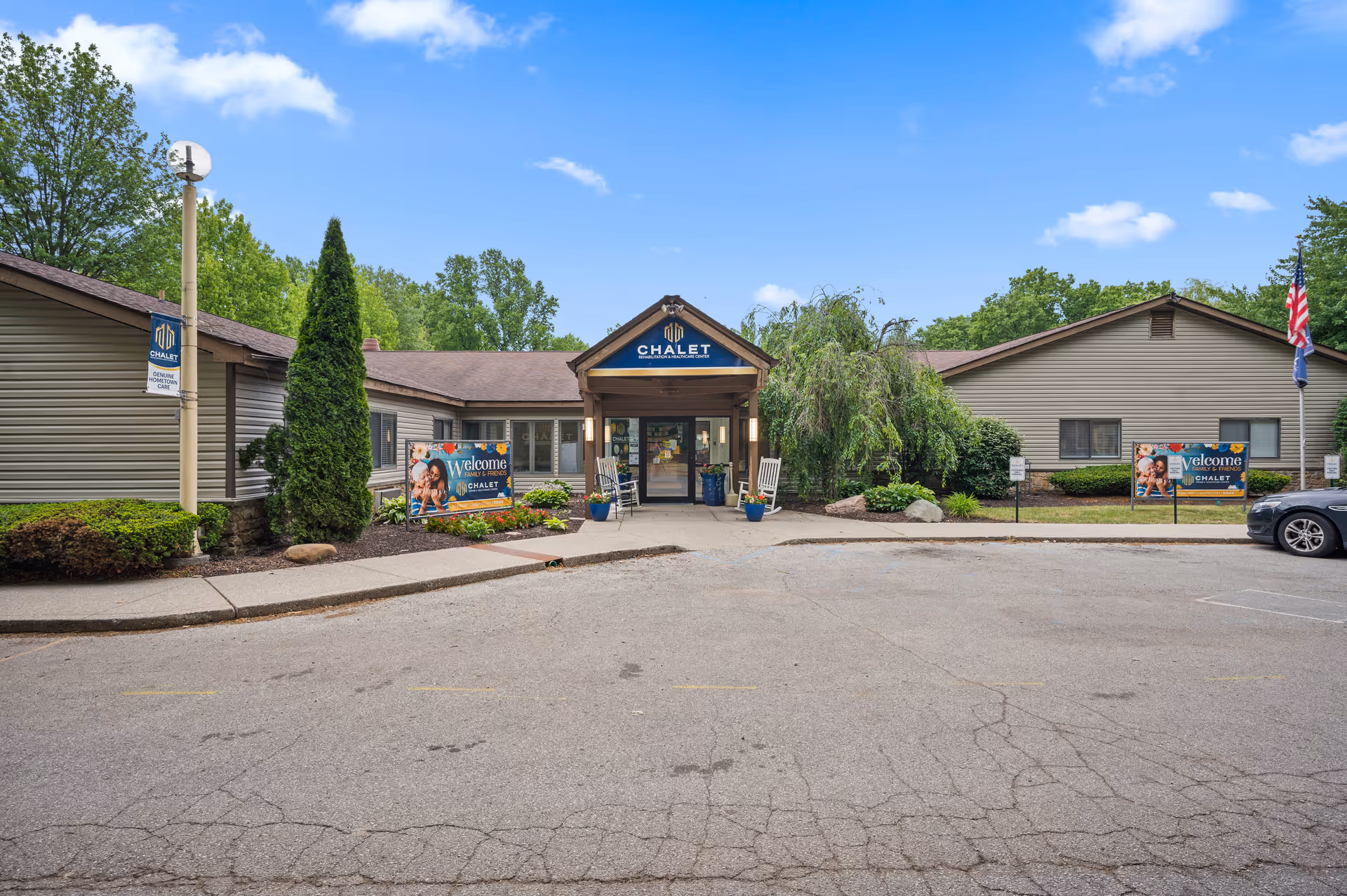 Front entrance of Chalet Rehabilitation and Healthcare Center, a single-story building with landscaping, welcome signs, and a parking area.