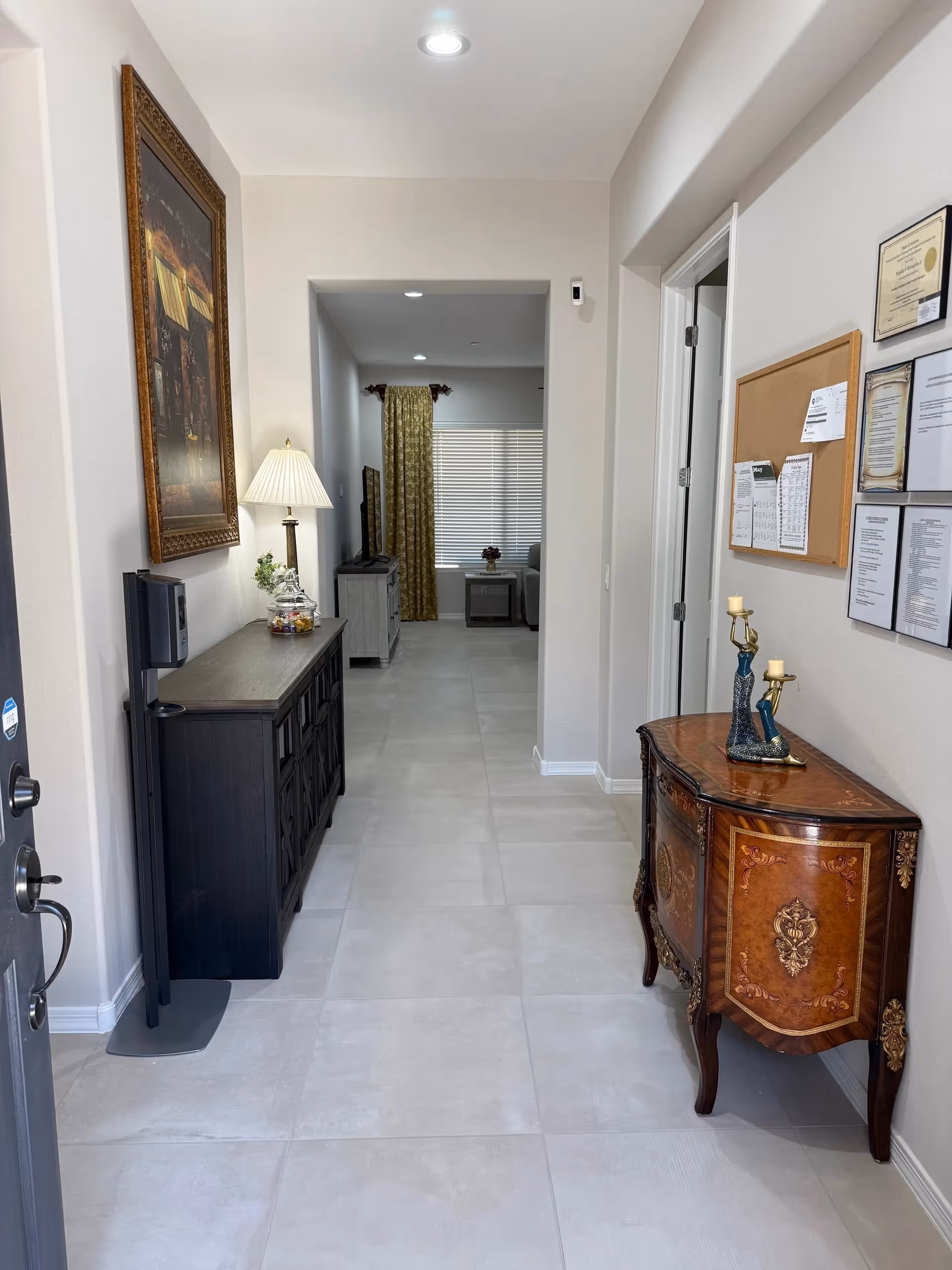 Bright hallway interior of a senior living facility with furniture, decor, and a distant living area.