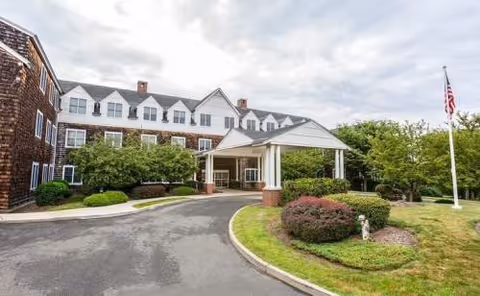 Exterior view of Benchmark Senior Living at Hamden with entrance portico and landscaped grounds.