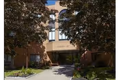 Exterior view of Wadsworth Glen Health Care and Rehabilitation Center showing the entrance with a pathway leading to the door, surrounded by trees and landscaping.
