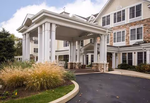 Exterior view of Sunrise of Dresher featuring a covered entrance and landscaped frontage.