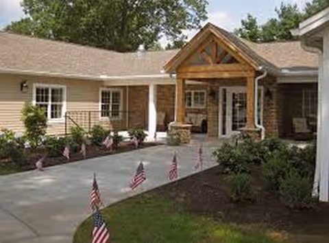 Exterior view of New Dawn Rehab and Healthcare Center entrance with American flags.