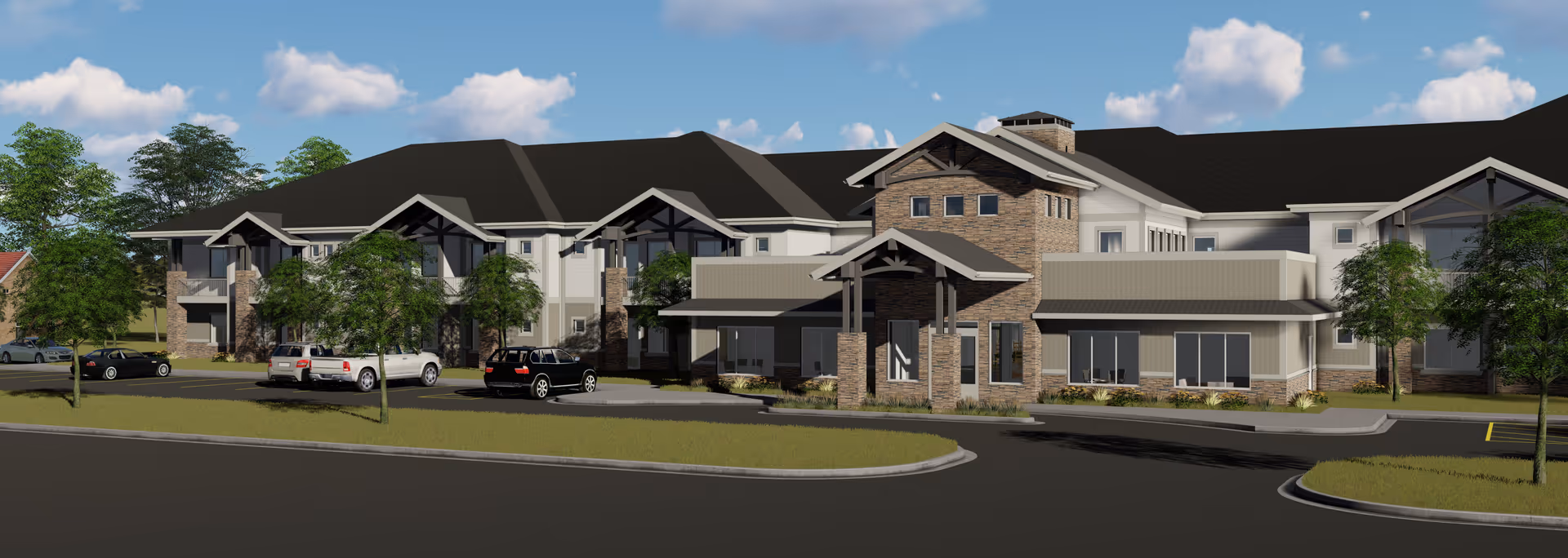 Exterior view of Birch Creek Assisted Living of Smithfield, showing a large two-story building with a combination of stone and light-colored siding, multiple windows, and a covered entrance. Several cars are parked in front, and there are trees and a clear blue sky with some clouds in the background.