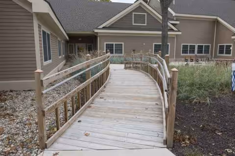 A curved wooden ramp leads to the Pine Ridge facility entrance.