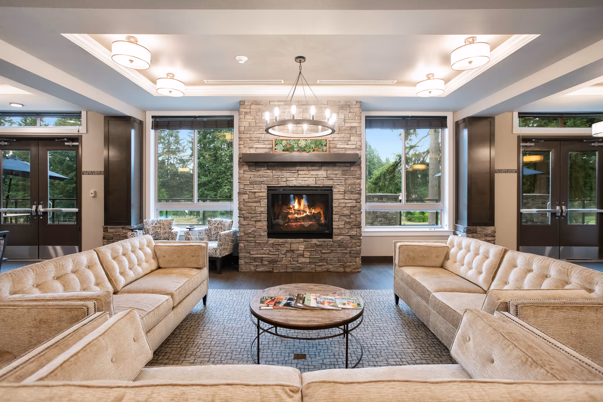 Comfortable communal lounge with sofas arranged around a central coffee table and a stone fireplace.