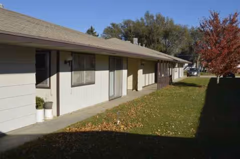 Exterior view of Linn Community Nursing Home with a row of single-story units and autumn leaves.