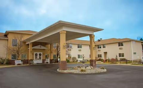 Exterior entrance of Avamere at South Hill with a covered drive-up canopy and seating.