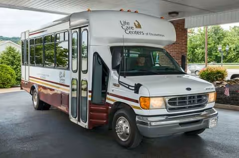 White Life Care Centers bus parked under a covered entrance at Elizabethton facility