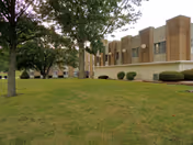 Exterior view of Pleasant View Nursing Home with brick building, windows, and green lawn.