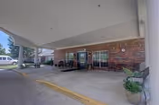 Covered entrance to Brookridge Cove Rehab and Care with brick exterior and parked car.