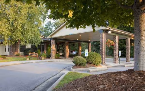Front view of The Laurels of Chatham entrance with brick columns and a covered driveway.