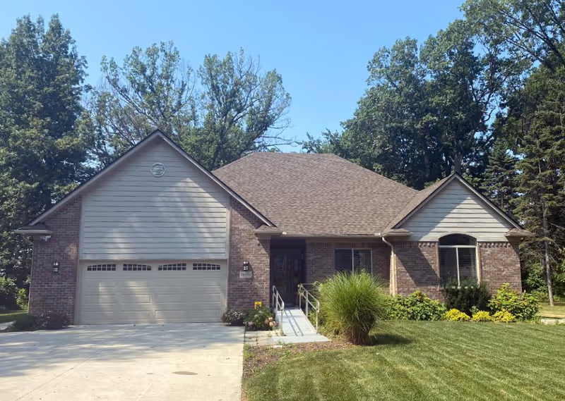 Front view of a brick senior living home with a two-car garage.