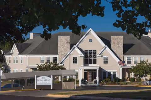 Exterior front view of Homestead at Hickory View with entrance and sign.