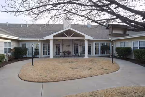 Exterior view of Lakewell Court senior living facility with a circular driveway and front porch.