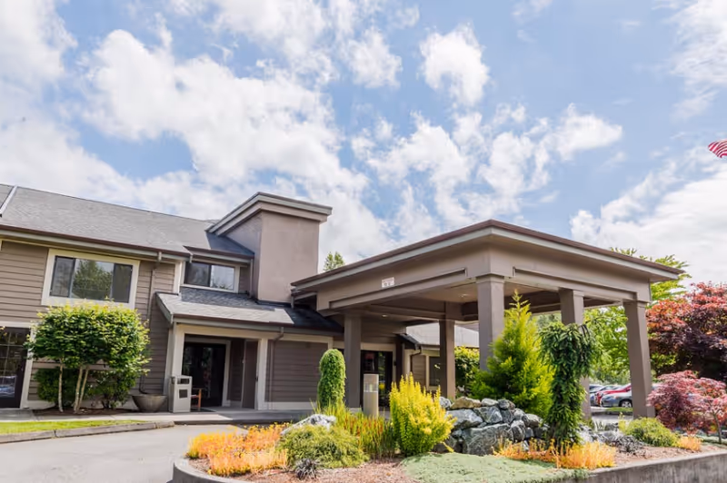 Front exterior of Village Concepts Sedro-Woolley Country Meadow Village entrance with landscaped plants.