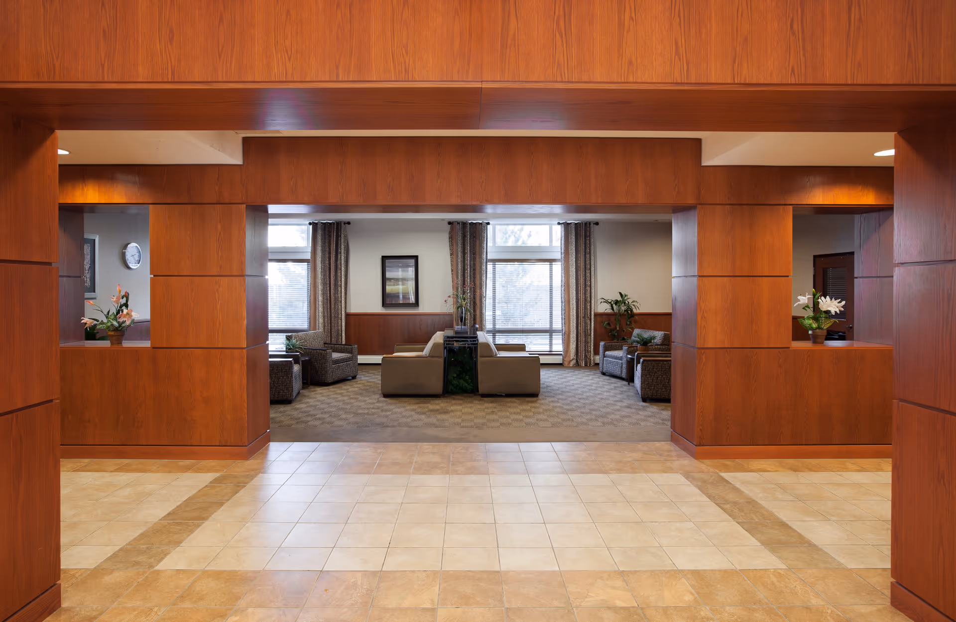 Spacious interior lobby with wood-paneled walls and a central seating area of sofas and armchairs.