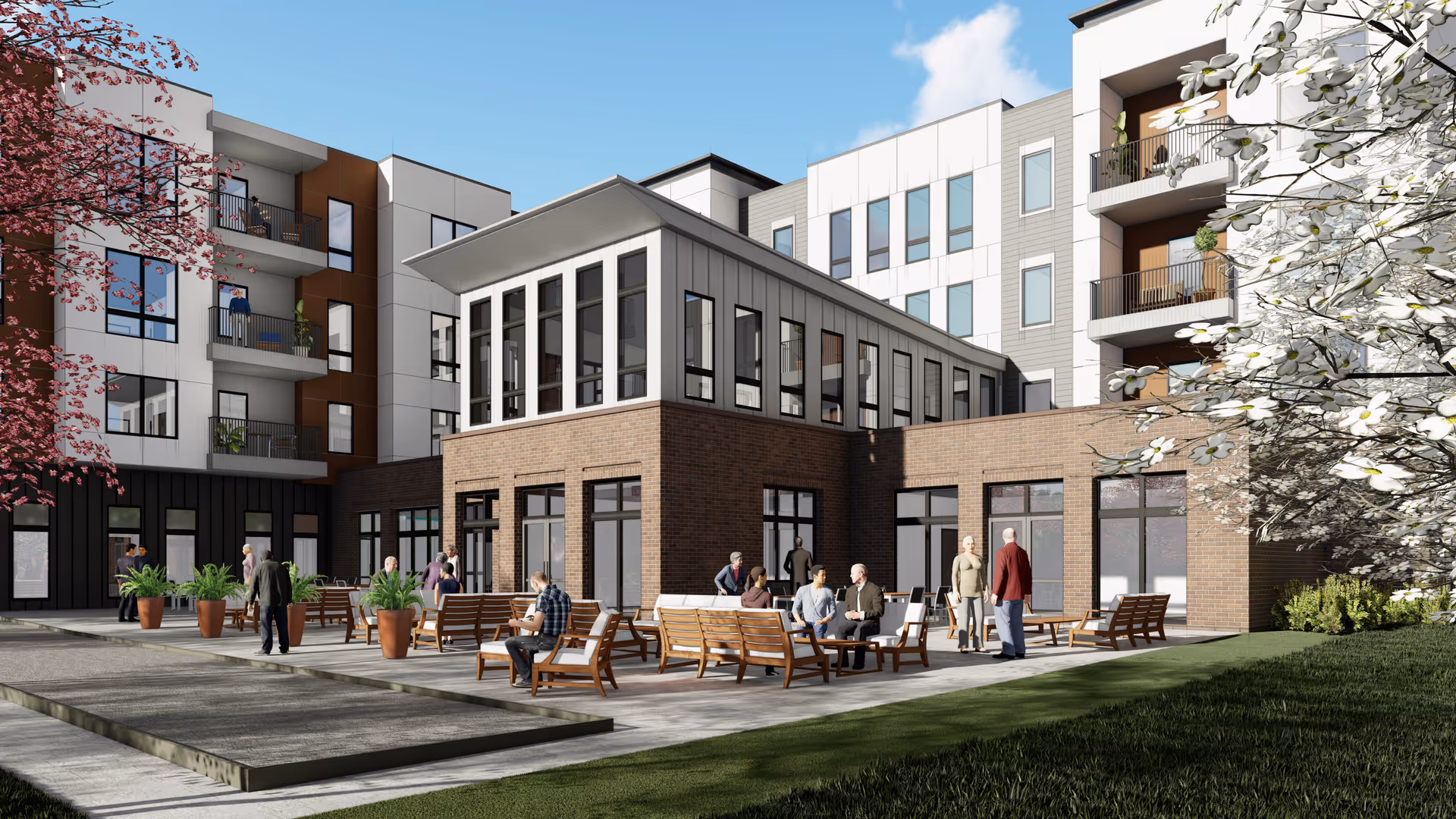Courtyard patio with benches and people socializing outside a modern multi-story senior living building.