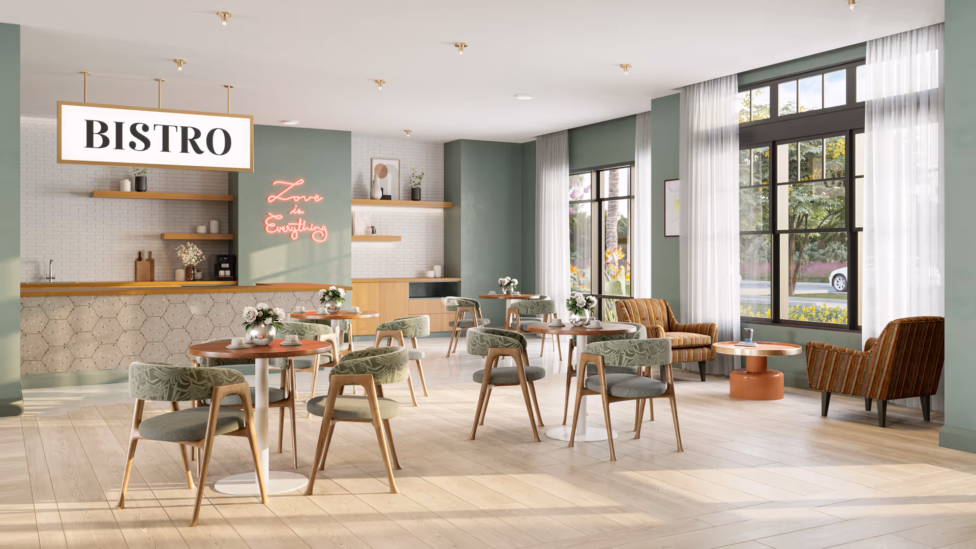 A bright and modern bistro dining area with round wooden tables and green cushioned chairs. The room features large windows with sheer white curtains allowing natural light to fill the space. There is a counter with hexagonal tile design and wooden shelves holding decorative items and a coffee machine. A neon sign on the wall reads 'Love Everything'.