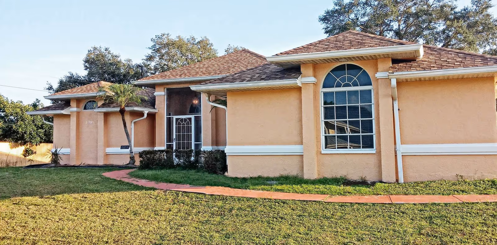 Grace Assisted Living facility exterior with peach walls, arched window, and curved walkway.