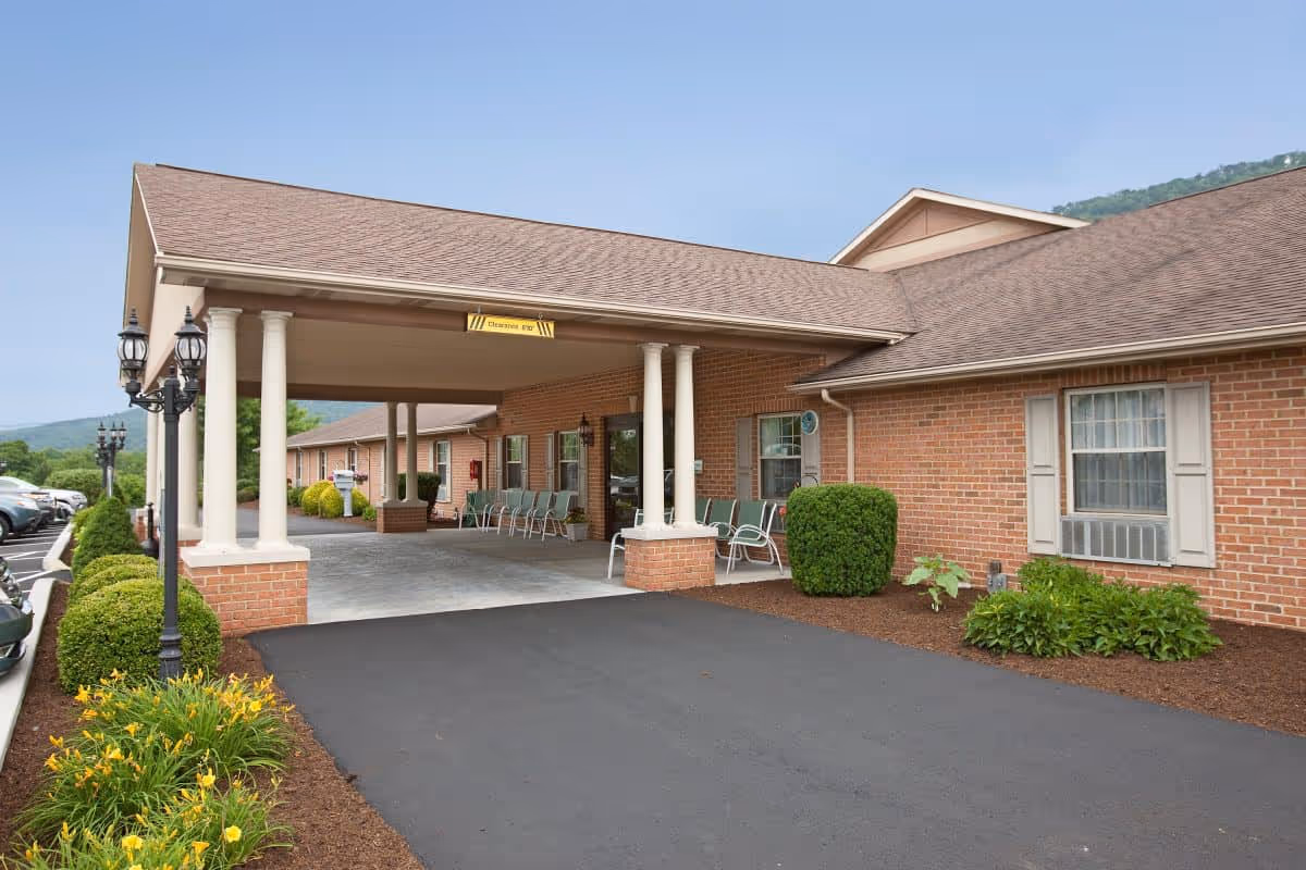 Colonial Courtyard at Bedford: brick senior living facility with covered entrance and seating.