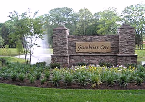 Stone entrance sign for Garden Plaza of Greenbriar Cove with fountain and flowers.