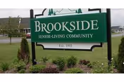 Exterior Brookside Senior Living Community sign with manicured landscaping in front of grass