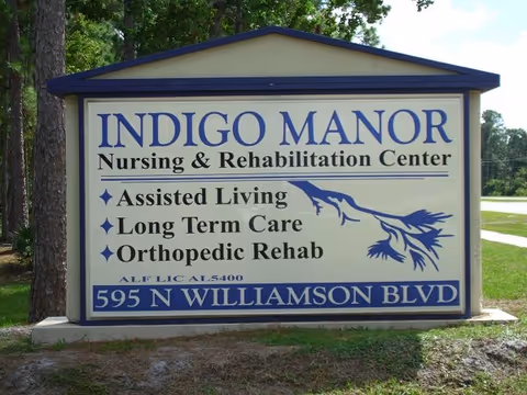 A large outdoor sign for Indigo Manor Nursing & Rehabilitation Center listing services including Assisted Living, Long Term Care, and Orthopedic Rehab, located at 595 N Williamson Blvd.