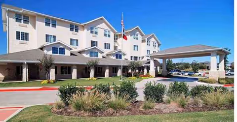 Dogwood Estates senior living building with a covered entrance, flagpole, and landscaped front yard.