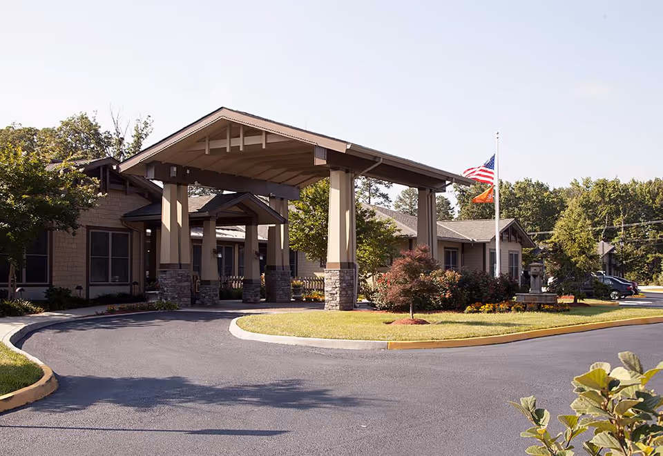 Exterior view of Sunrise at Bon Air senior living facility featuring a covered entrance and landscaped surroundings.