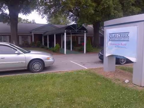 Exterior view of Silas Creek Rehabilitation Center entrance with parked cars