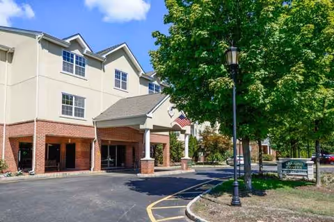 Front exterior view of Horizons at Franklin Lakes with entrance, brick columns, and surrounding greenery.
