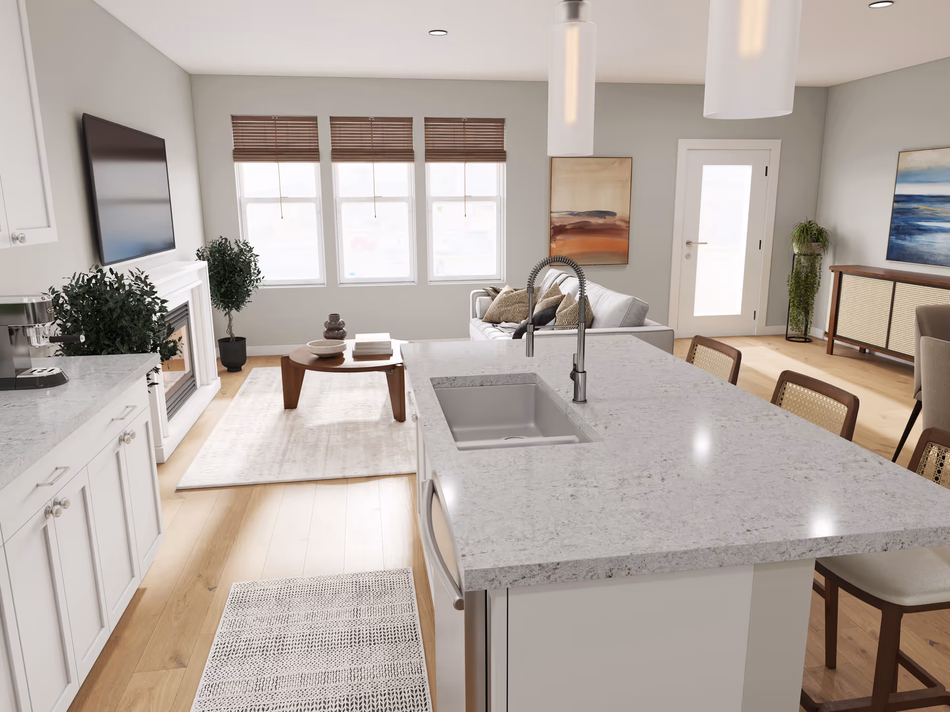 Bright and modern open-concept living space featuring a kitchen island with a sink and faucet in the foreground, white cabinetry, a coffee machine, a fireplace with a mounted TV above it, a coffee table on a rug, a sofa with cushions, large windows with wooden blinds, and decorative plants and paintings on the walls.