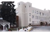 Cream-colored senior living building with arched entrance and gazebo.