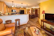 Open communal living area with a kitchen bar, dining table, and sofa.