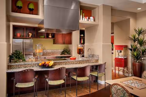 Modern kitchen area in a senior living facility with curved counter and bar stools.